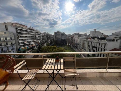 a balcony with two chairs and a view of a city at Maria's Sunlit Apartment in Piraeus