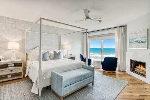1 dormitorio con cama con dosel y chimenea en Elegant Oceanfront Penthouse with Panoramic view, Omni Resort, Sea Dunes, en Amelia Island