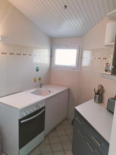 une petite cuisine avec un évier et une fenêtre dans l'établissement Maison calme proche mer - La Roseraie, à Saint-Hilaire-de-Riez