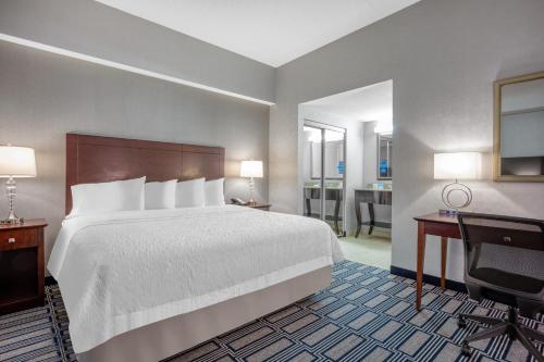 a hotel room with a large bed and a desk and a desk at Hampton Inn & Suites Providence Downtown in Providence