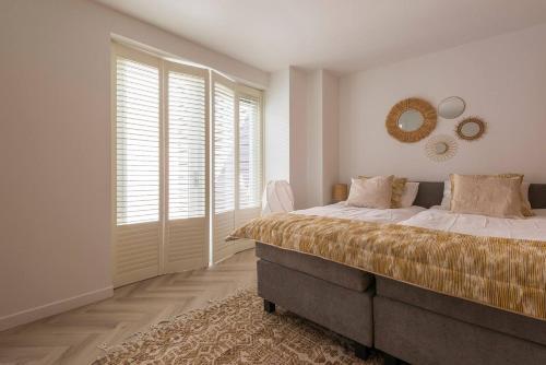 1 dormitorio con cama y espejo en la pared en New Luxurious Apartment With 2 Bedrooms & Garden, en Roosendaal