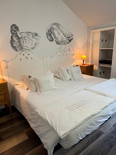 a bedroom with a white bed with a drawing on the wall at Casa de Juste in Lousada