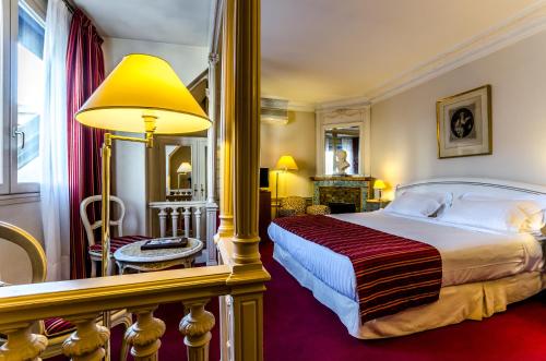 um quarto de hotel com uma cama grande e um candeeiro em Hôtel Langlois em Paris