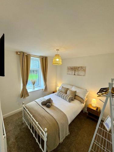sypialnia z dużym białym łóżkiem i oknem w obiekcie Spacious home near park and playing fields w mieście Aberdare