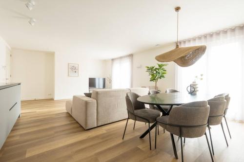 a living room with a table and a couch at New Apartment In City Centre Large in Oirschot