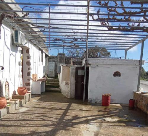 a building with awning over a courtyard at οικία ΦΥΝΤΙΚΑΚΗ - SKALA in Anópolis