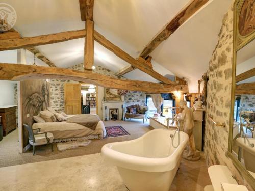 La salle de bains est pourvue d'un lit et d'une baignoire. dans l'établissement Gîte de Charme avec Piscine, Spa et Sauna, 5 Chambres, Jardin Privé et Équipements Modernes - FR-1-496-311, à Luré