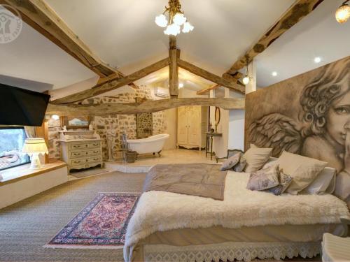 une chambre avec un grand lit et une baignoire dans l'établissement Gîte de Charme avec Piscine, Spa et Sauna, 5 Chambres, Jardin Privé et Équipements Modernes - FR-1-496-311, à Luré