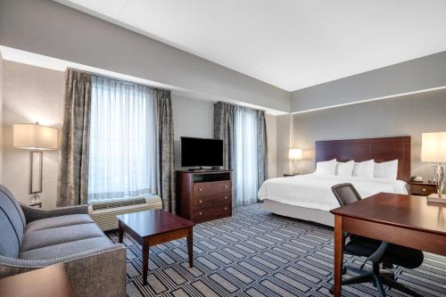 a hotel room with a king sized bed and a desk at Hampton Inn & Suites Providence Downtown in Providence
