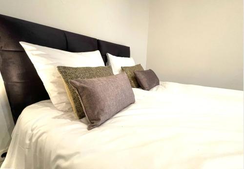 Una cama con sábanas blancas y almohadas. en Modern Studio In Tilburg Kitchen & Bathroom en Tilburg