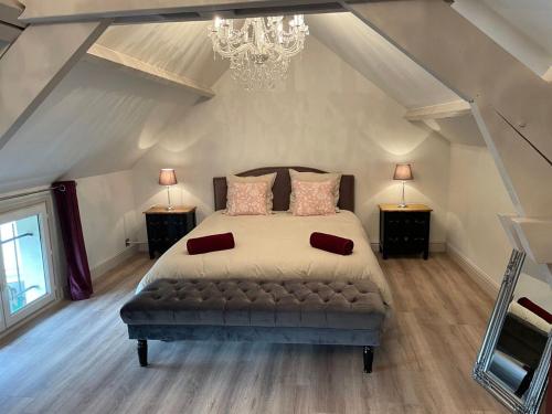 a bedroom with a bed with two night stands and a chandelier at Gîte Moulins-sur-Yèvre, 4 pièces, 6 personnes - FR-1-586-42 