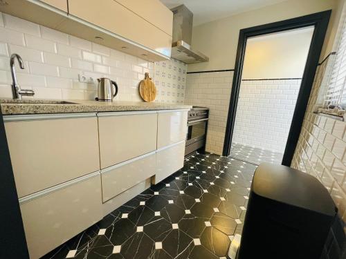 uma cozinha com pisos em azulejo preto e branco e um balcão em Room In The Center Of Tilburg Low Budget em Tilburg