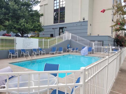 una piscina con sillas azules y un edificio en Best Western Plus Dalton Inn, en Dalton