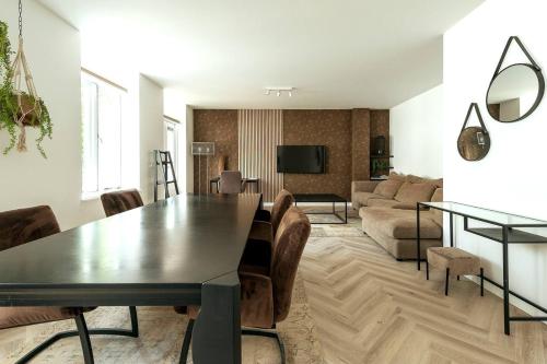 un soggiorno con tavolo e divano di Jean New Luxurious Home With Balconies Room 3 a Roosendaal