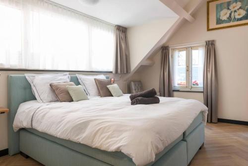 a large bed in a room with windows at Unique Luxurious Warm Room New in Tilburg