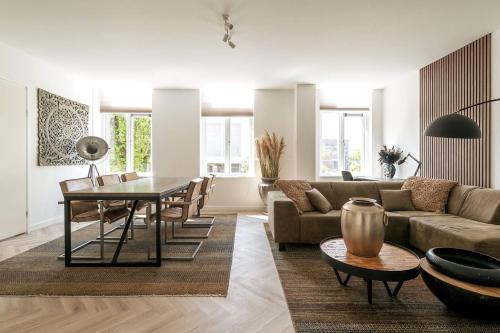 ein Wohnzimmer mit einem Sofa und einem Tisch in der Unterkunft Chris New Luxurious Home With Workspace in Roosendaal