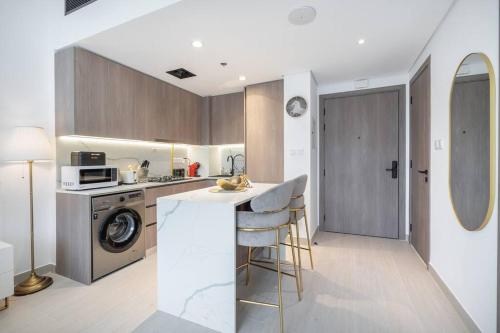 a kitchen with a counter and a washer and dryer at Brand New Listing & Studio City & Czechin in Dubai