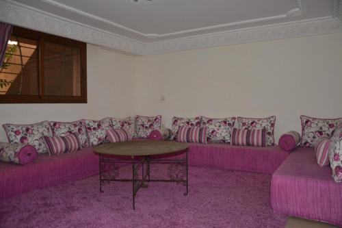 a living room with a purple couch and a table at Elegant villa for family and business trips in El Jadida