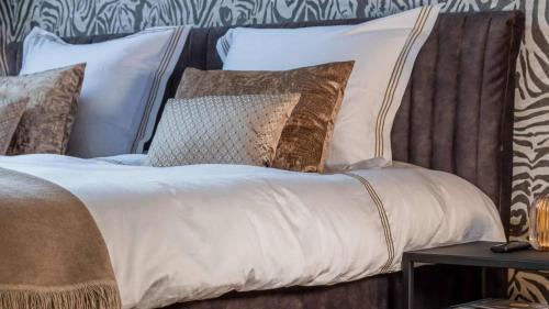 uma cama com almofadas castanhas e brancas em Luxe Suite With Garden And Bath Sophie em Tilburg