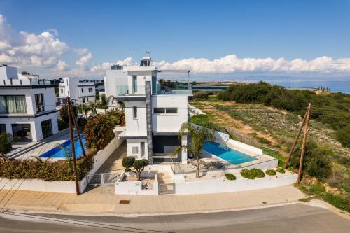 an aerial view of a white house with a swimming pool at Seaside Luxury Villa with Heated Pool in Paralimni
