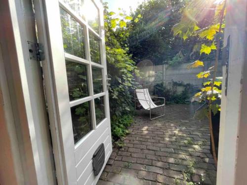 une porte menant à une terrasse avec une chaise. dans l'établissement Lovely House Casa Colores Center 7p, à Tilbourg