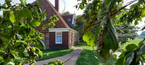 a house viewed through the leaves of trees at Aan de Dijk in Edam