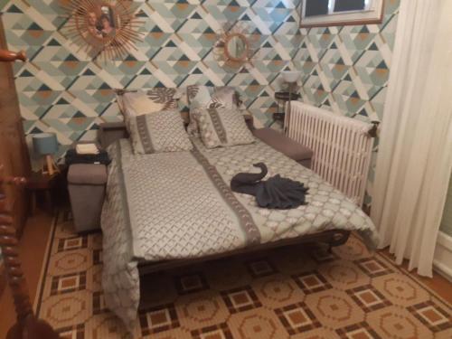une chambre avec un lit avec un cygne noir dessus dans l'établissement Maison familiale avec piscine chauffée, jardin et activités, 5 chambres, 10 pers, Merck-Saint-Liévin - FR-1-376-117, à Merck-Saint-Liévin