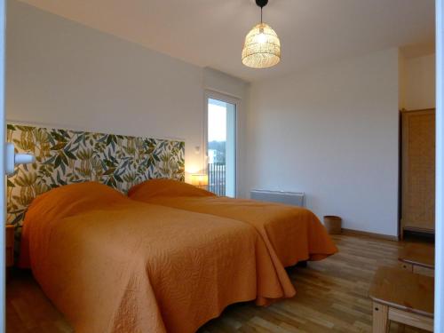 a bedroom with a bed with an orange blanket at Appartement spacieux avec rooftop et garages privés à 3 min de la gare d'Épernon - FR-1-581-129 in Épernon