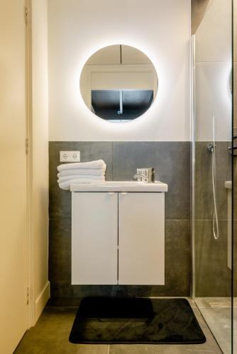 a bathroom with a white sink and a mirror at Child favorite coach house city villa tilburg in Tilburg