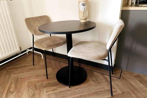 een kleine tafel met twee stoelen en een vaas erop bij Cozy Studio Unit With Kitchen & Bathroom in Tilburg