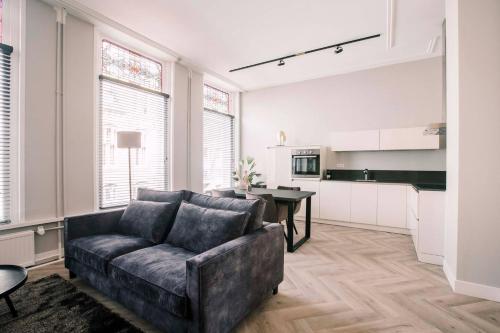 a living room with a couch and a kitchen at Large Apartment With 2 Bedrooms Stadsvilla in Tilburg