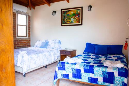 een slaapkamer met een bed en een stoel erin bij VÉLEZ Beach Hotel in San Juan del Sur