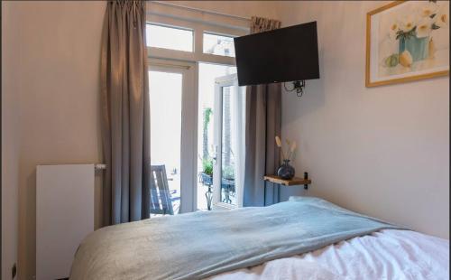 a bedroom with a bed and a large window at Cozy Room, Just Renovated in Tilburg
