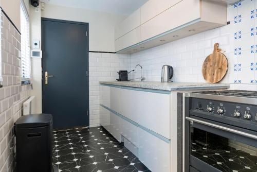 a kitchen with white appliances and a black door at Lovely Suite Newly Renovated in Tilburg