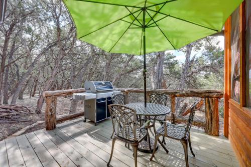 a table and chairs on a deck with an umbrella at Lakewood Secret Cabin about 4 Mi to The Lake! in Canyon Lake