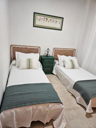 duas camas sentadas uma ao lado da outra num quarto em Arenal golf Sun & golf em Benalmádena