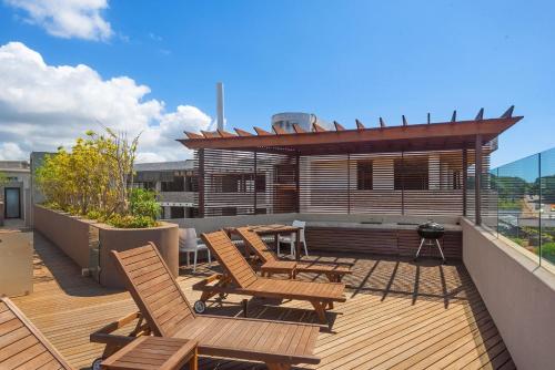 a deck with chairs and a table on a roof at 105 On KOI by Host Agents in Ballito