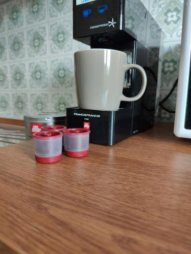 a coffee maker with three cups next to a coffee mug at Bed and Breakfast Cattinara in Trieste