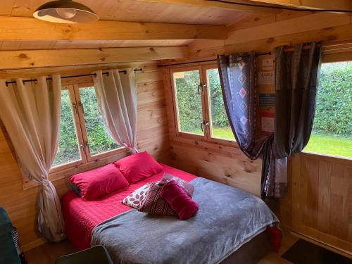 1 dormitorio con 1 cama en una cabaña de madera en Caravane Ruby, 