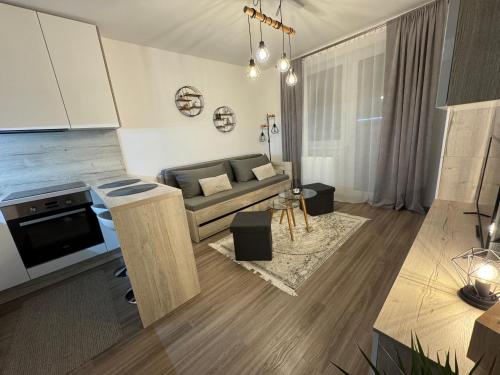 uma sala de estar com um sofá e uma mesa em Moderný apartmán s výhľadom na Vysoké Tatry em Poprad