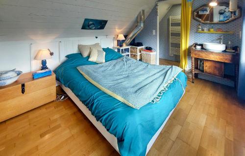 1 dormitorio con 1 cama grande y edredón azul en Gorgeous Home In Pleumeur-bodou With Kitchenette en Pleumeur-Bodou