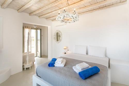 um quarto com uma cama com toalhas azuis em Manolia Luxury Private house by Mykonian Kazarte em Kalo Livadi