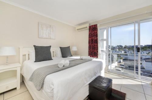 a bedroom with a large bed and a large window at Ocean Tides 35 in Bloubergstrand