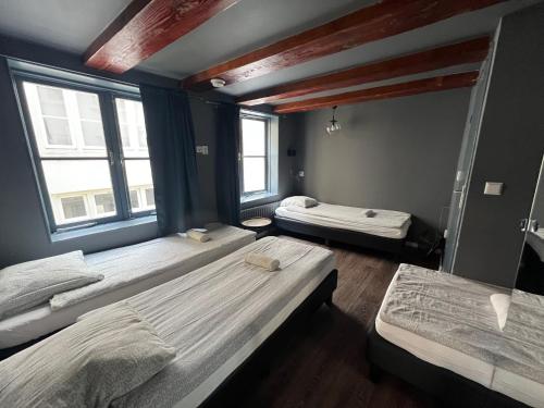 a room with three beds and two windows at 7B&B in Amsterdam