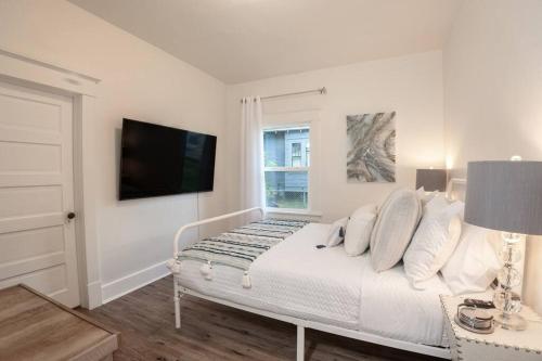 a white bedroom with a bed and a window at Renovated 3bd 1bth Home in North Spokane Near DT in Spokane