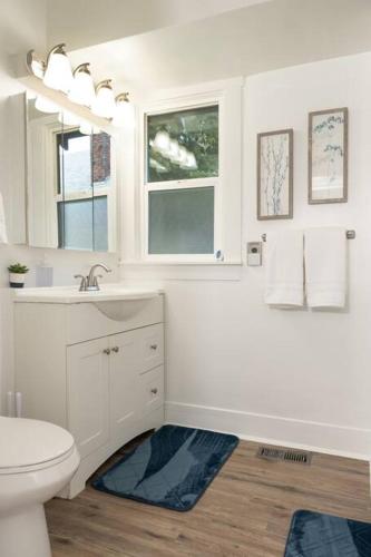 a white bathroom with a toilet and a sink at Renovated 3bd 1bth Home in North Spokane Near DT in Spokane