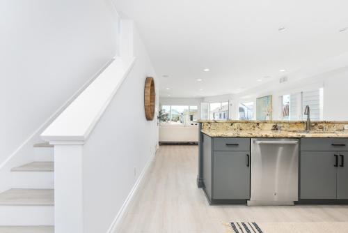 Una cocina blanca con fregadero y encimera. en Luxury 3 Bedroom walk to Beach & Pier, en Newport Beach