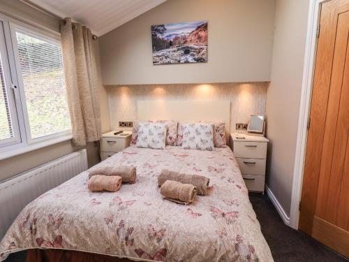 a bedroom with a large bed with two pillows on it at Lakeland View Lodge in Windermere
