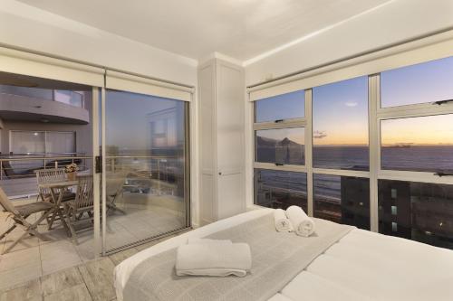 a bedroom with a bed and a view of the ocean at Ocean View B901 in Bloubergstrand