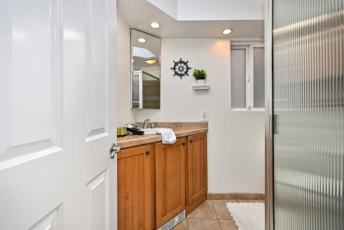 uma casa de banho com um lavatório e um espelho em Freshly Renovated Beach House Steps to the Beach em Newport Beach